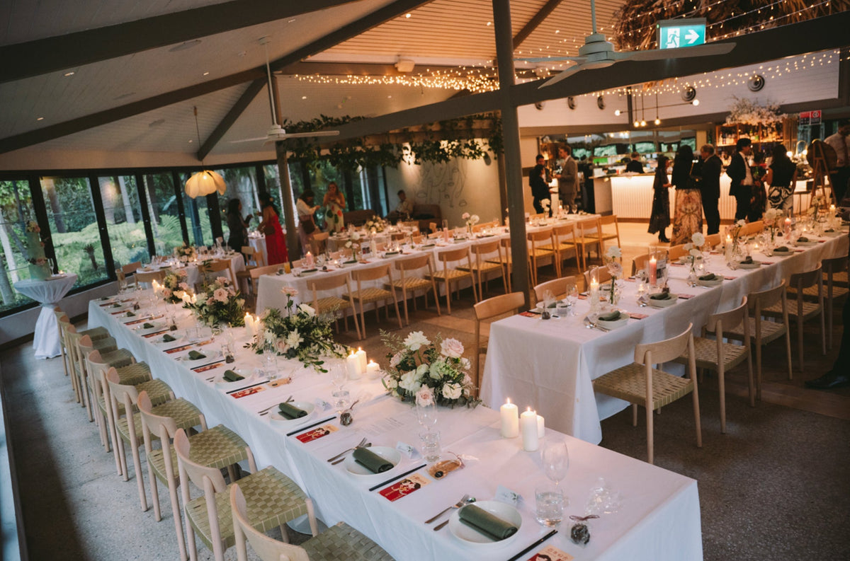 Botanic House set for a wedding reception with long tables, white flowers and candles under fairy lights, by Lime Tree Bower Florist