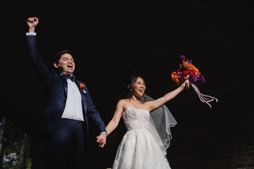 Samantha and Zi after their ceremony with a bright pink, orange and purple bouquet